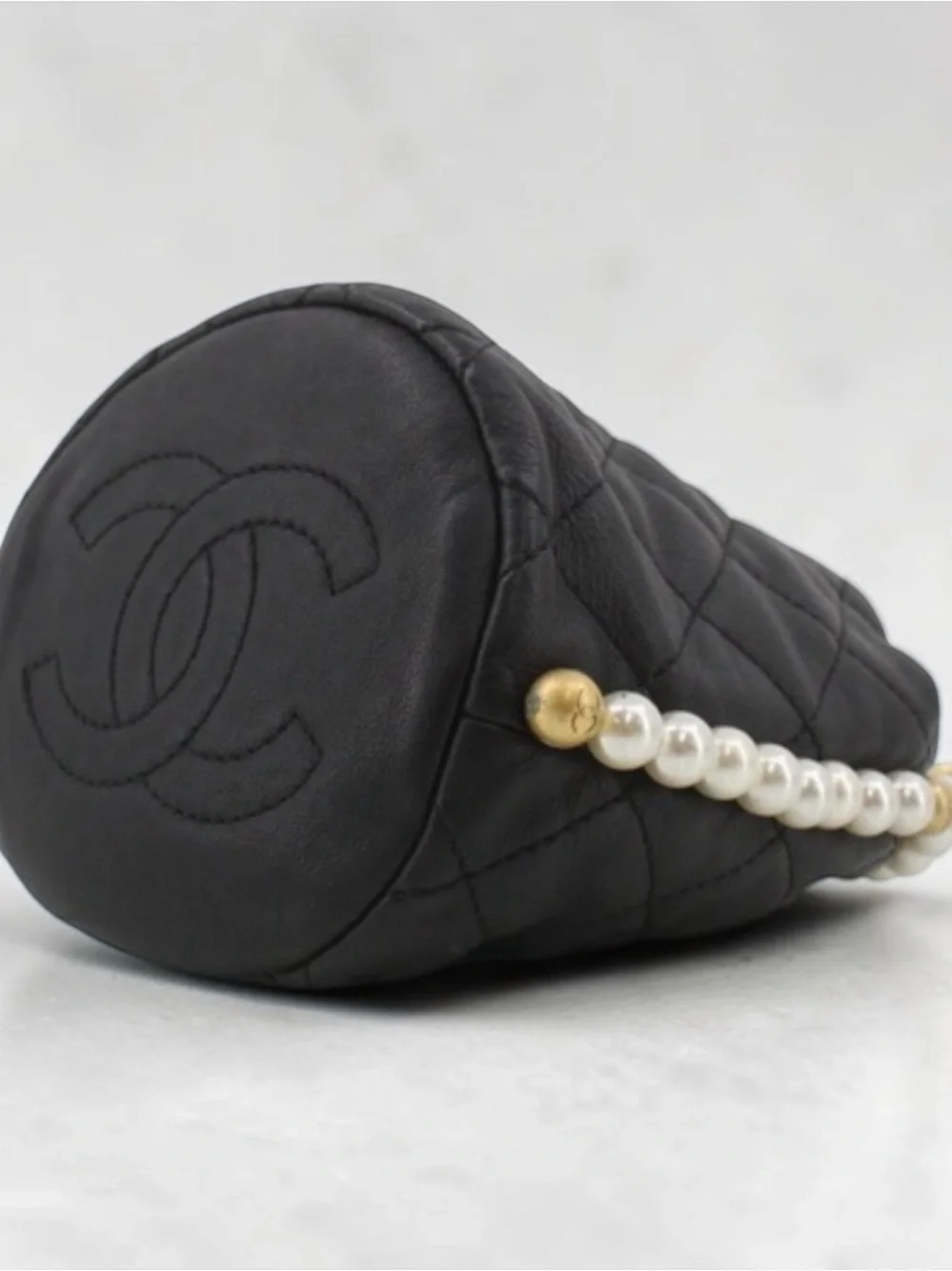 CHANEL Pearl Drawstring Bucket Bag in Black Quilted Lambskin with Pearl Strap